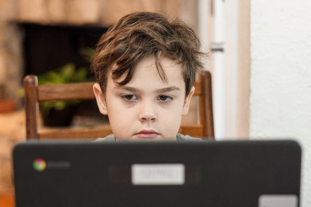 A small guy watching at a computer screen