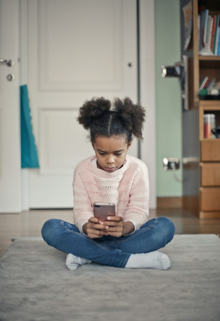 young child using social media on cell phone